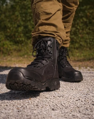 Primer plano de borcegos de seguridad Alfa dando un paso, destacando el cierre lateral.