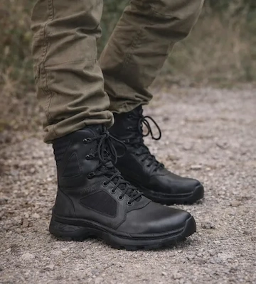 Borcegos tácticos Alfa de perfil en terreno agreste con pantalón cargo.